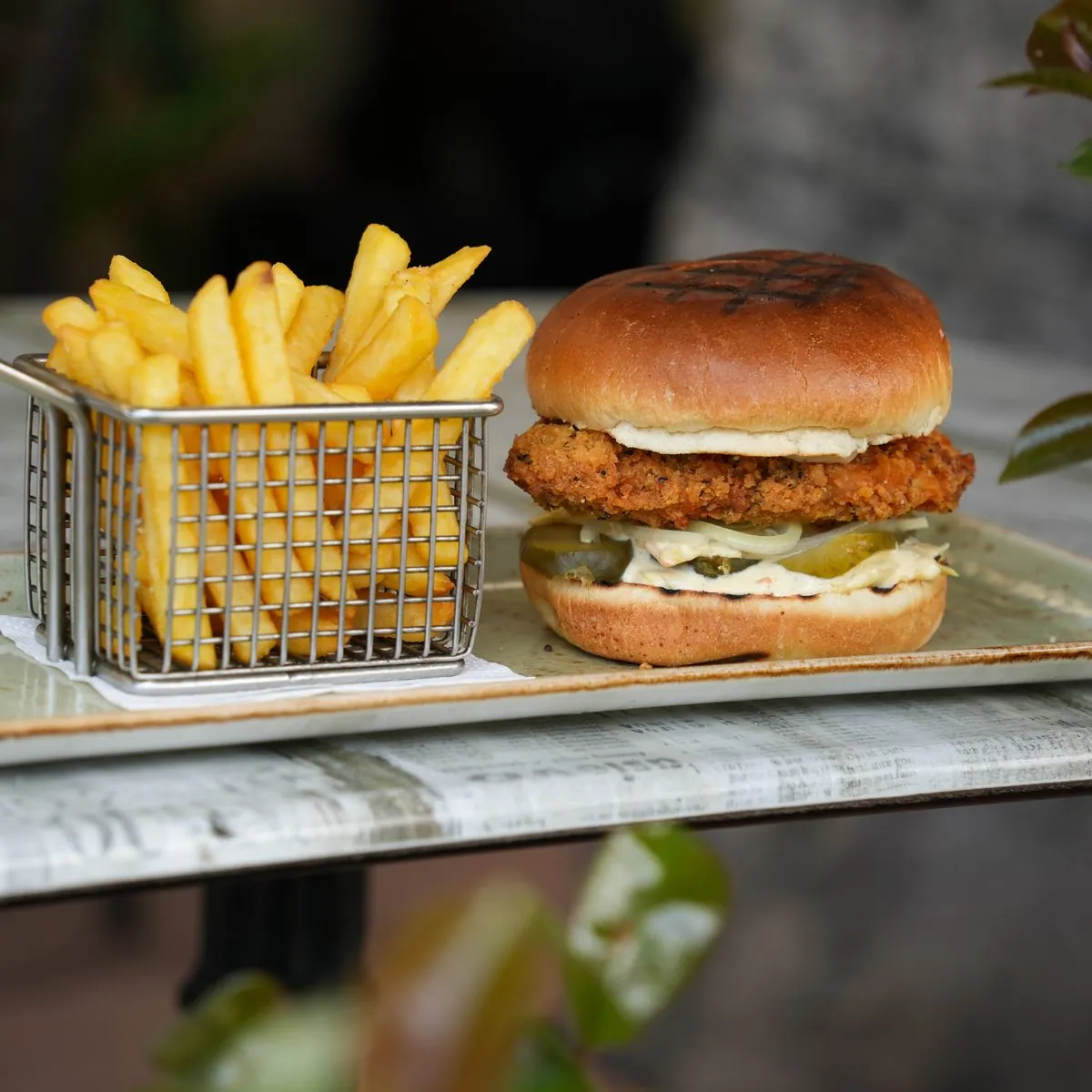 Chicken burger served with a basket of fries